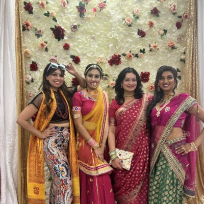 Four ladies in Indian attire posing for a photo